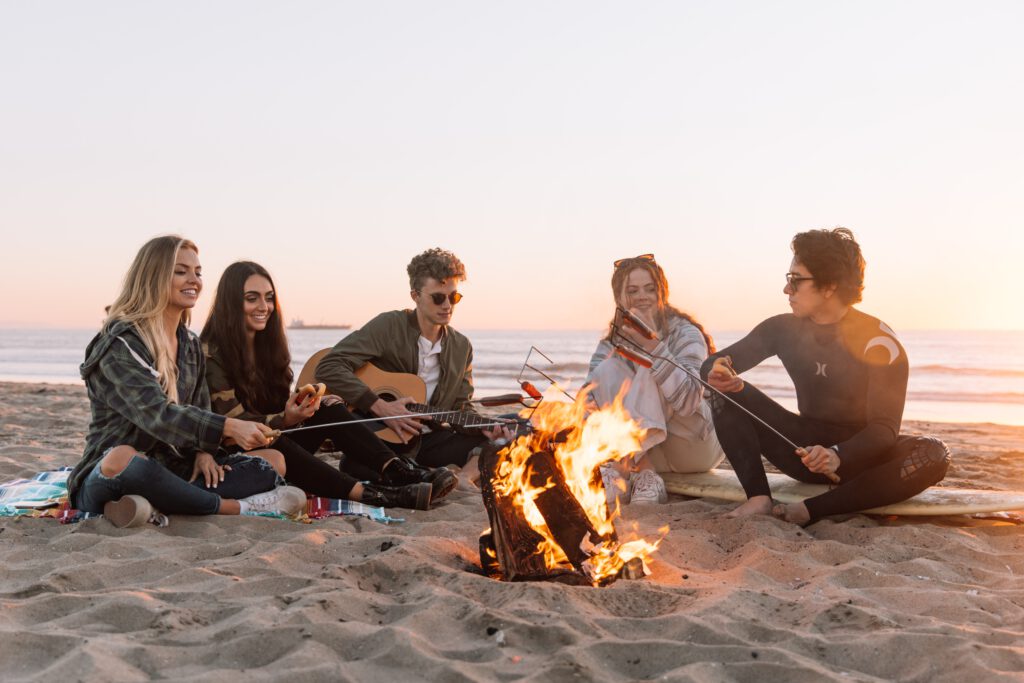 Achtsamkeit bedeutet Momente, wie zum Beispiel mit Freunden am Strand an einem Lagerfeuer zu sitzen, bewusst wahrzunehmen 